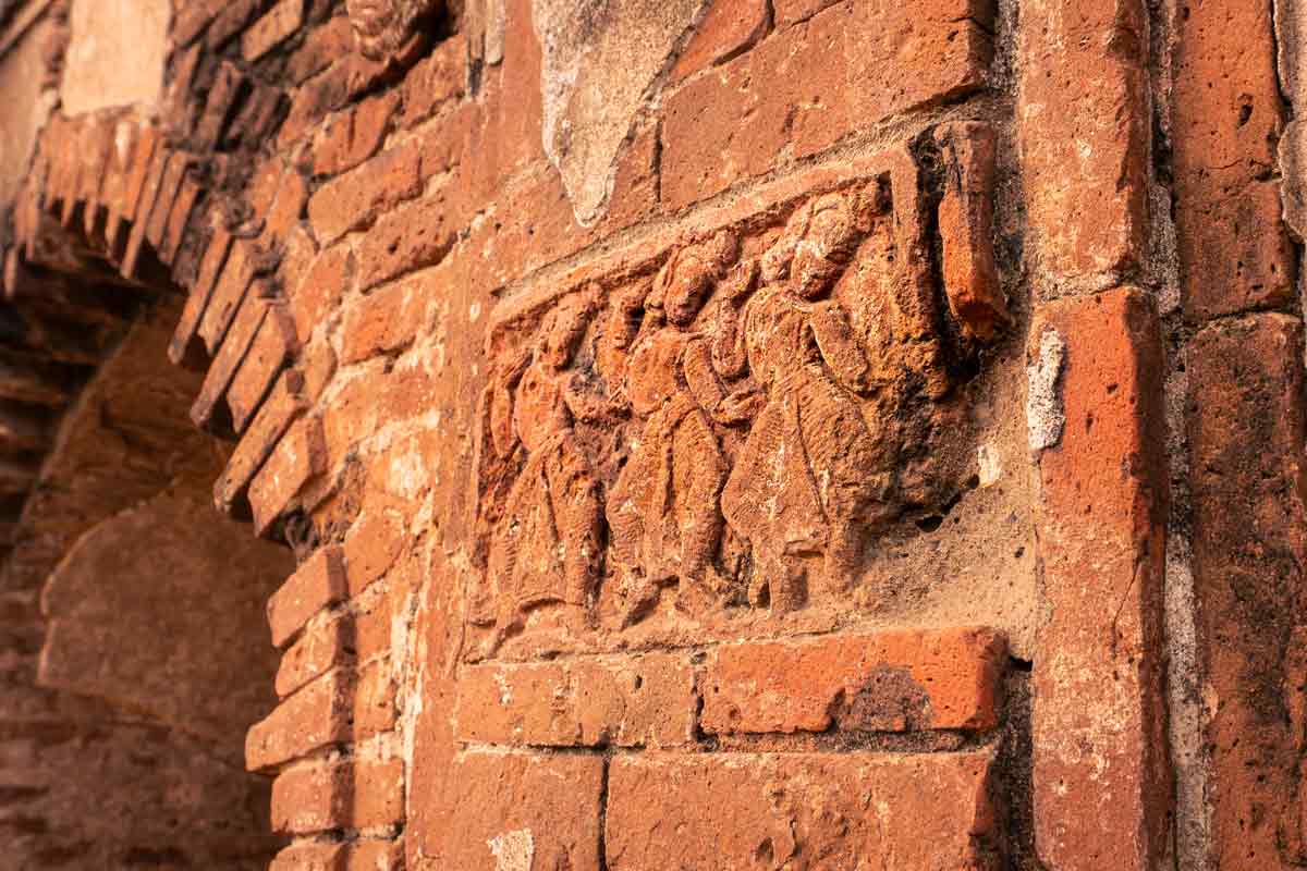 dancing sculptures carved on a terracotta wall